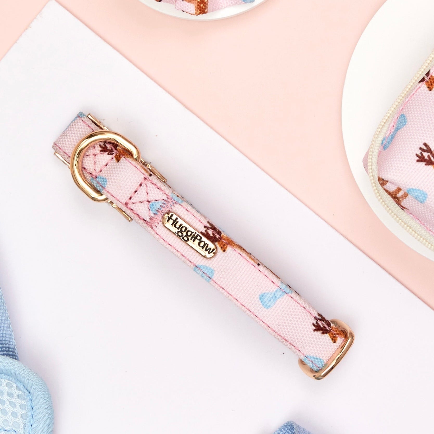 Pink floral dog collar with gold hardware on a white surface