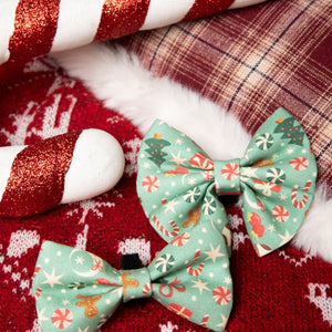 Two green floral-patterned bows on a red fabric background with candy canes.