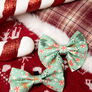 Two green floral-patterned bows on a red fabric background with candy canes.