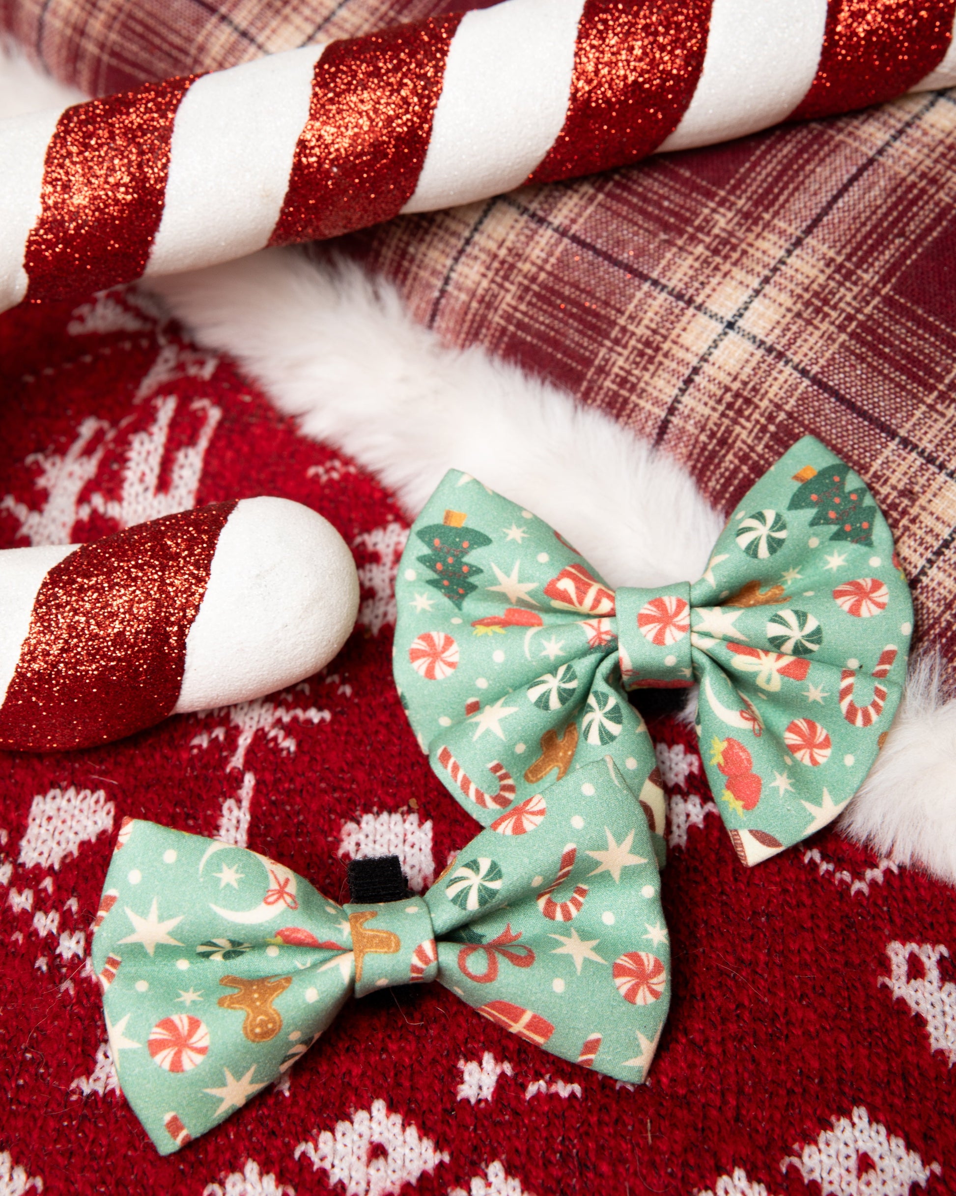 Two green floral-patterned bows on a red fabric background with candy canes.